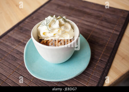 Kaffee Granit mit weißer Schokolade Schaum und wildem Fenchel, in einer blauen Tasse mit Disch, Umgebungslicht. Stockfoto