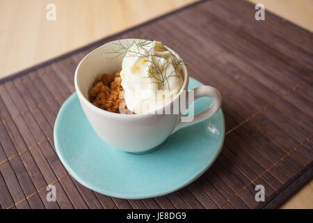 Kaffee Granit mit weißer Schokolade Schaum und wildem Fenchel, in einer blauen Tasse mit Disch, Umgebungslicht. Stockfoto