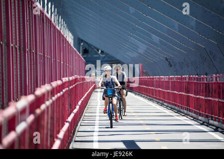 Asiatische Touristen mit dem CitiBike Fahrrad Teilen auf der Williamsburg Bridge, New York City Stockfoto