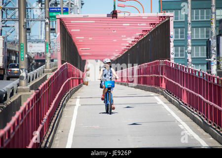 Asiatische Touristen mit dem CitiBike Fahrrad Teilen auf der Williamsburg Bridge, New York City Stockfoto