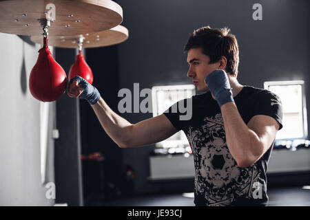 Gut aussehender Mann Training Punsch zum Stanzen von Birne Stockfoto