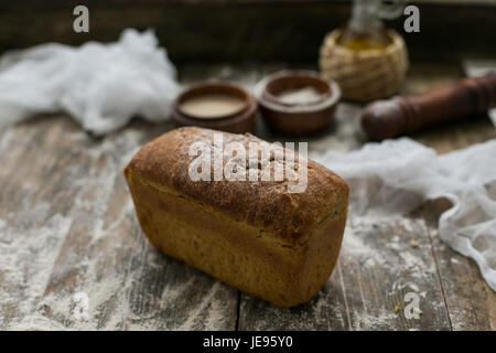 Nahaufnahme der frische braune knusprigen Laib Brot liegen auf dem Holztisch mit Mehl bestreut Stockfoto