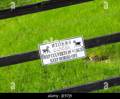 Eine Warnung Schild mit der Aufschrift "Fahrer Gefahr, die Tiefe Durchlässe in Verges Pferde halten Sie ab" Stockfoto