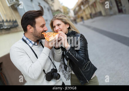 Junges attraktives Paar teilen Stück pizza Stockfoto