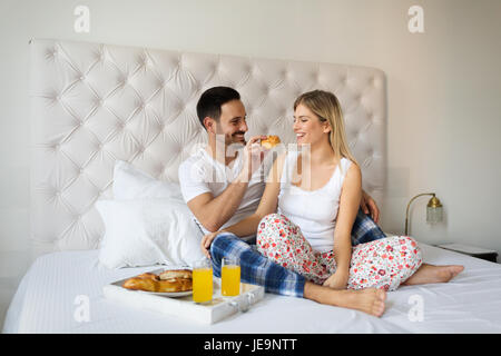 Romantisches Brautpaar mit Frühstück im Bett Stockfoto