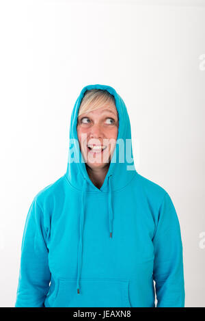 Schöne europäische Mitte Alter Frau mit blonden Haaren, gekleidet in eine leichte blaue Lässige Kapuzenjacke - Studio erschossen vor einem weißen Hintergrund Stockfoto