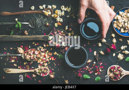 Chinesischer Schwarztee in Steinzeug Tassen in der Hand des Mannes Stockfoto