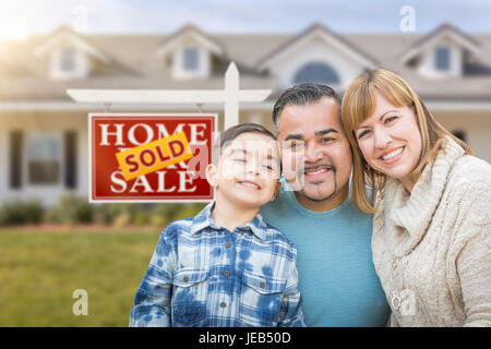 Gemischte Rassen Familie vor der Haus und verkauft für Immobilien Verkaufsschild Stockfoto