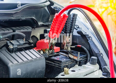 Laden Autobatterie mit Strom Trog Starthilfekabel, rote und schwarze Starthilfekabel Stockfoto