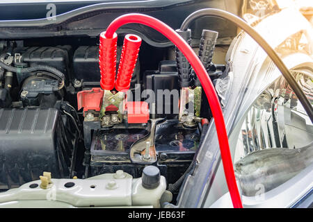 Laden Autobatterie mit Strom Trog Starthilfekabel, rote und schwarze Starthilfekabel Stockfoto