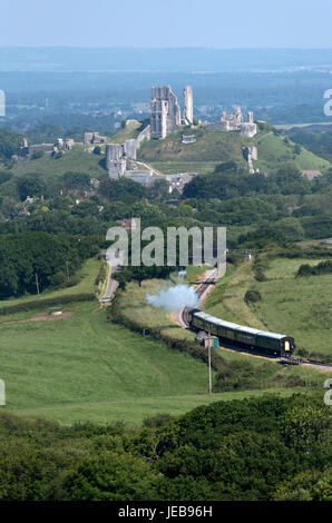 Dampfzug mit einem Hintergrund der Corfe Castle auf der Swanage Railway in Dorset England UK. Juni 2017 Stockfoto