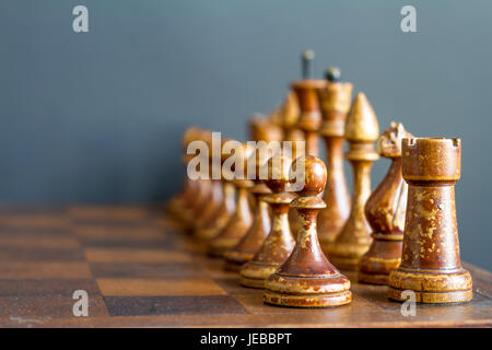 Alte hölzerne Schachfiguren auf einem alten Schachbrett. Stockfoto