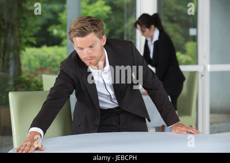 junge Arbeitnehmer Reinigung Tisch im restaurant Stockfoto