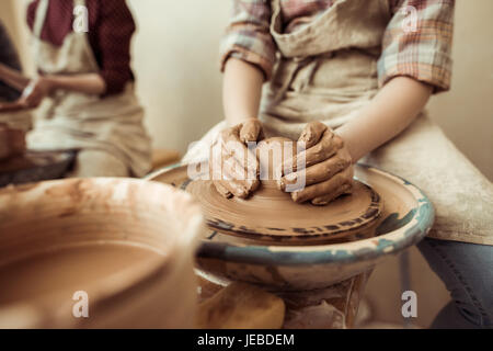 Nahaufnahme eines Kinderhände arbeiten auf der Töpferscheibe in Werkstatt Stockfoto
