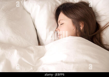 Junge Frau, die gut unter der warmen Decke schlafen Stockfoto