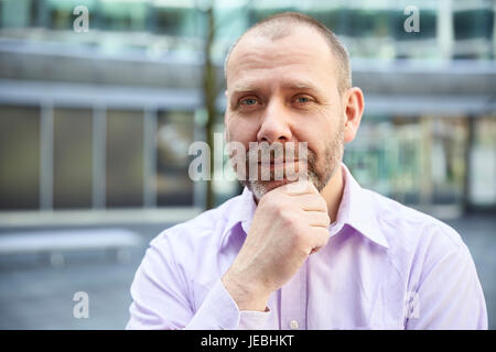 Outdoor Portrait nachdenklich Geschäftsmann vor seinem Büro. Stockfoto