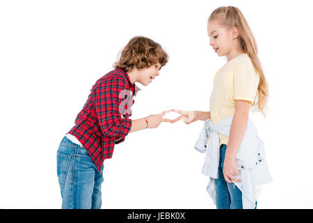 Netten jungen und Mädchen spielen in Stein-Schere-Papier-Spiel isoliert auf weiss Stockfoto