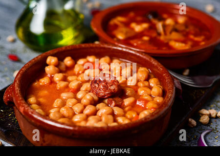 Nahaufnahme von einem Steingut-Schale mit Potaje de Garbanzos, ein Kichererbsen-Eintopf mit Chorizo, Serrano-Schinken und eine Schüssel mit Callos, eine typische Rind Kutteln s Stockfoto