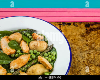 Hähnchen-Salat mit Spargel Erbsen Spinat und Kartoffeln auf ein Backblech Stockfoto