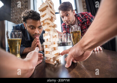 junge Männer Bier trinken und Jenga-Spiel zu spielen. junge Leute, die Spaß Konzept Stockfoto
