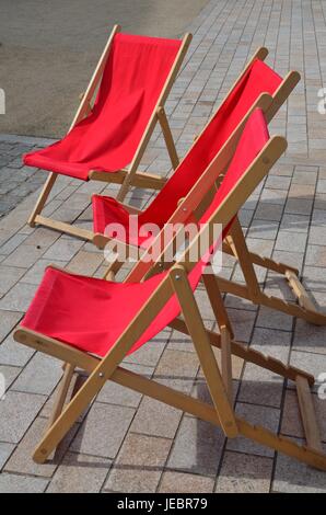 Drei rote Liegestühle in der Sonne Stockfoto