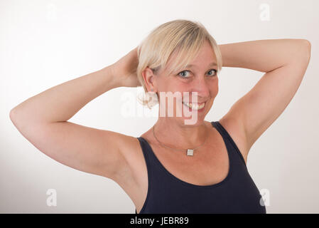 Porträt von einer attraktiven Blondine Rothaarige Mitte Alter Europäerin trägt blaue Top Smiley - halbe Körper - Studio Schüsse aufs weiße Hinterg zeigt hautnah Stockfoto