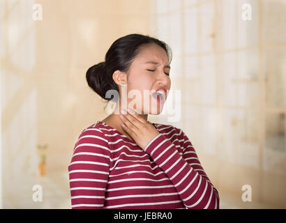 Junge lateinamerikanische Frau posiert für die Kamera zeigt Anzeichen von Nackenschmerzen, Hand in Hand auf schmerzhafte Körperteil, Verletzungen Konzept. Stockfoto