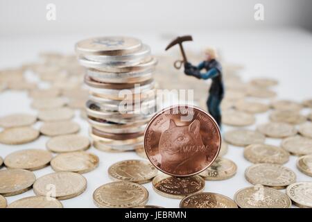Kryptowährung physische Messing Dogecoin Münze in der Nähe von Bitcoin Münzen und Bergmann. Stockfoto