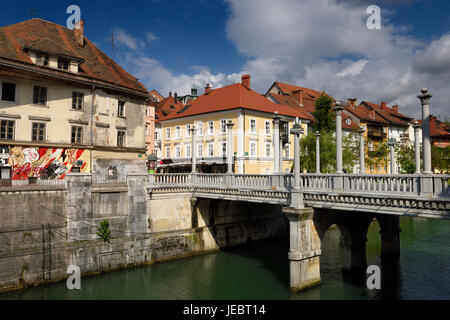 Spalten auf die Plecnik konzipierte Schuhmacher-Brücke über den Fluss Ljubljanica mit alten und renovierten Häusern Ljubljana Slowenien Stockfoto