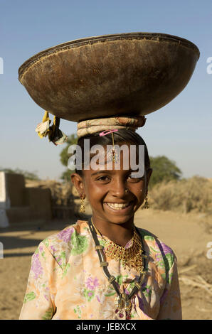 Indien, Rajasthan, Jaisalmer Region, Dorf Khuri, kleines Mädchen mit Last auf dem Kopf, Porträt, Stockfoto