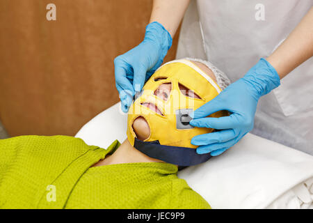 Hardware-Kosmetik. Mikrostrom. Gesichtsverjüngung mit Hilfe der Microcurrent Therapie. Stockfoto