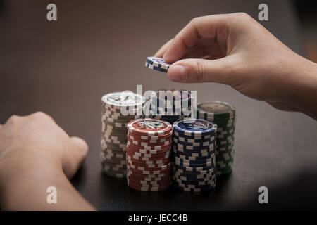 Mannes Hände ziehen sich einen grossen Haufen Pokerchips Stockfoto