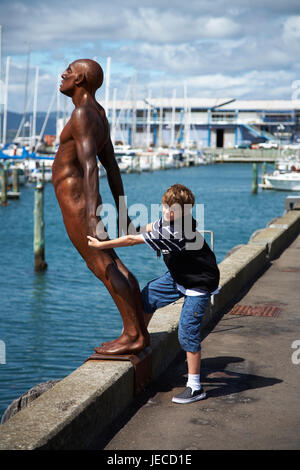 Junge (12) Iteracting mit Wellington Waterfront Max Patte, Skulptur, Trost im Wind Stockfoto