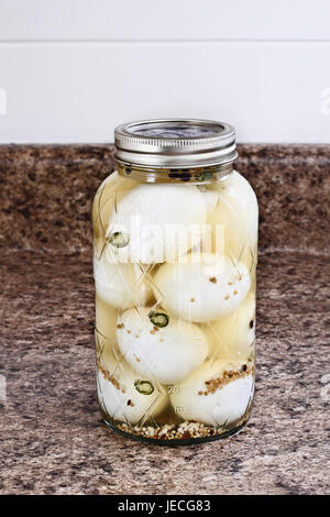 Einmachglas gefüllt mit alten altmodischen eingelegten Eiern zu Hause erhalten. Stockfoto