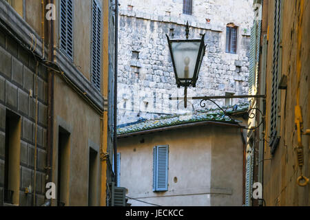 Reisen Sie nach Italien - Laterne zwischen mittelalterlichen Häusern auf Straße in Siena Stadt im winter Stockfoto