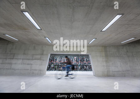 Moderner Bahnhof mit Bikestands Rush - Mann geht zu seinem Fahrrad und pendeln nach Hause (Farbe getönt; Bewegung verschwommenes Bild) Stockfoto