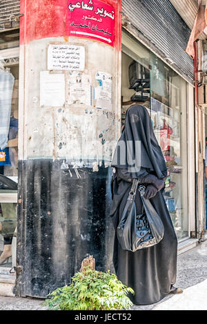 Muslimische Frau vollständig abgedeckt von Kopf bis Fuß in schwarzen Schleier und Handschuhe. Stockfoto