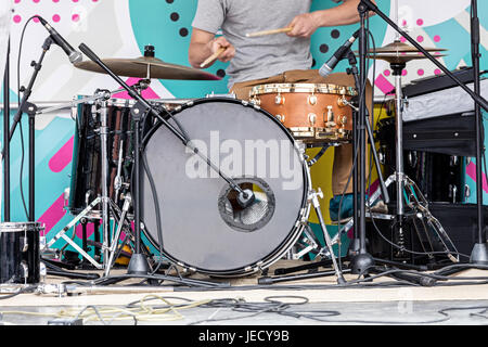 junge Musiker spielt Schlagzeug auf Freilichtbühne während des Musikfestivals Stockfoto