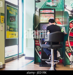 Mann mit Roulette Spielautomaten (FOBT in Wettbüros in England Wetten zu festen Quoten Terminal), UK Stockfoto