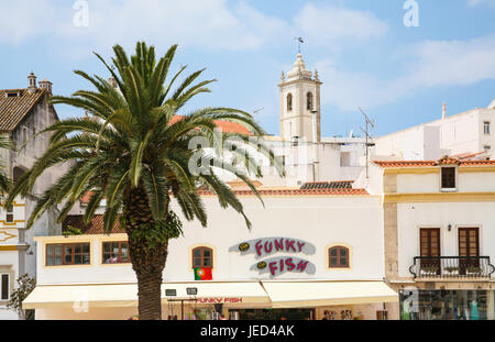 ALBUFEIRA, PORTUGAL - 17. Juni 2006: Einkaufsstraße am Hauptplatz und Ansicht des Bell Tower of St Sebastian Church (Igreja Matriz de Sao Sebastiao) in Stockfoto