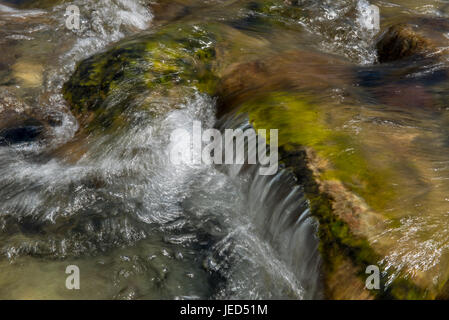 Wasser fließt über Felsblöcke in Cumbria, Langstrath Beck Stockfoto