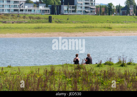 DEVENTER, Niederlande - 27. August 2016: zwei unbekannte Frauen sitzen an einem Fluss Stockfoto