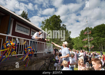 Åländischen Schären, Ostsee, Finnland, 23. Juni 2017 Mittsommer in der nordischen Region. Menschen weiterhin die Tradition vieler Jahrhunderte an diesem Feiertag in der nordischen Region durch Aufstellen von Mittsommer Pole (Maibaumkraxeln), singen Lieder und traditionelle Tänze. Im Bild: Mehrere hundert nehmen Teil in einem altmodischen Lotterie, nachdem die Mittsommer-Pole in Pålsböle in Finström ausgelöst wird. Foto: Rob Watkins/Alamy Live-Nachrichten Stockfoto