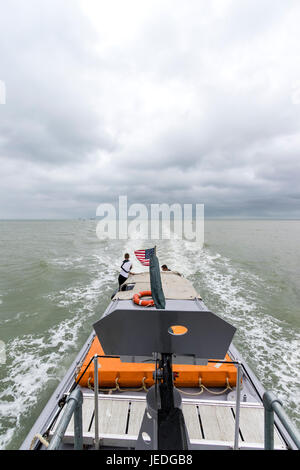 Blickrichtung von der Brücke zum Heck des Bootes verlassen in das Meer. Stürmisches Wetter. Geschützturm im Vordergrund. P22 wieder Rhein Patrouillenboot. Wehende US-Flagge. Stockfoto