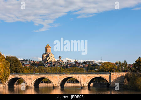 Saarbrücken-Brücke mit der Sameba-Kathedrale im Hintergrund in Tiflis, Georgien. Stockfoto