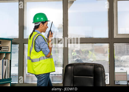 Weibliche Steinbrucharbeiter im Baubüro am Funkgerät sprechen Stockfoto