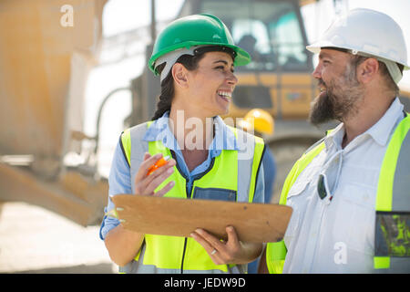 Männliche und weibliche Steinbrucharbeiter vor Ort diskutieren Stockfoto