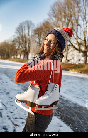 Glückliche Frau am Kanal tragen Schlittschuhe Stockfoto