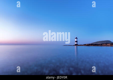 Trywn Du Leuchtturm (Penmon Leuchtturm), mit Puffin Insel im Hintergrund, Dinmor Punkt, Penmon, Anglesey, Wales, UK. Stockfoto