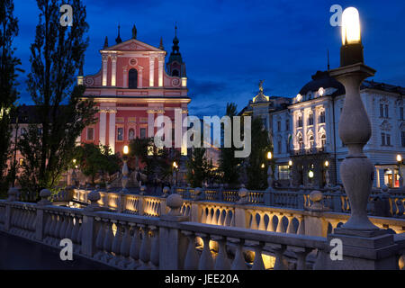 Lichter auf rosa Fassade der Franziskanerkirche der Verkündigung und Central Apotheke Preseren Square in der Abenddämmerung Triple Bridge Ljubljana Slowenien Stockfoto